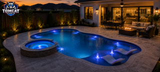 Freeform pool with round spa, in-water loungers, and fire pit lounge by Tomcat Pools