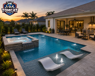 Pool with raised spillover spa and white in-water loungers by Tomcat Pools